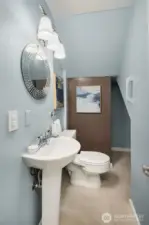 Convenient half bath on main level includes extra storing shelving around the corner..