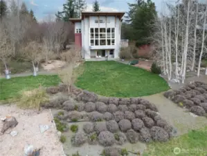 1221. View of the gardens and the house beyond. Those plants in front are lavender plants.