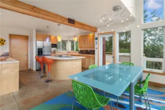 1221. Looking from the dining area towards the kitchen. Door on the left leads to a walk-in pantry. Door on the right leads to a large deck, perfect for BBQ or being out in nature.As you gaze from the dining area into the kitchen, the layout invites you to explore. To your left, a convenient walk-in pantry awaits, perfect for all your storage needs. To your right, a spacious deck beckons, ideal for hosting barbecues or simply soaking in the beauty of nature.