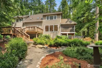 The southern side of the home has serene views of the forest from inside the home, or on a sunny day, your expansive deck. This sweet path meanders around the front yard.