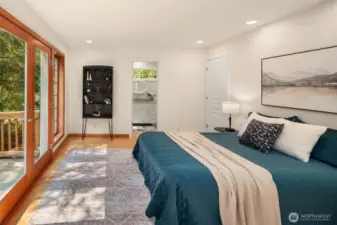 The ensuite primary is just off the LR, behind a hidden door. Dual walk-in closets, french doors to the deck and a tiled bathroom.