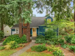 Delightful storybook Cape Cod surrounded by beautiful Evergreens and lush landscape.