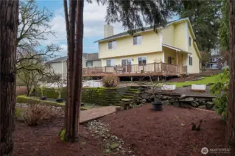 Beautiful photo highlighting the landscaping and upkeep done by the owners, which includes evergreen trees, fruit and flowering trees, shrubs, bulbs (soon!), and raised garden beds.