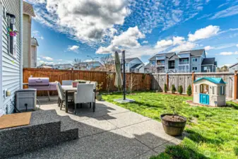 Large patio, flowering plants throughout the front and back yards.