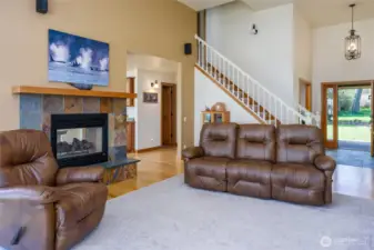 Spacious living room has vaulted ceiling and double sided, propane fireplace.