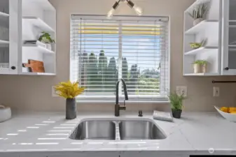 Lovely quartz countertops and no-edge sink are beautiful upgrades in this home.