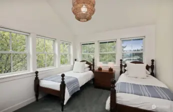 Still on the upper level, and now in the northeast corner of your home, this bedroom has a full bath adjacent to it. There is a walk in closet in the hallway before you enter this bedroom. Vaulted ceilings and walls of windows invite so much light.