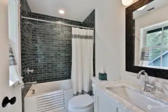 This full bath is adjacent to the bedroom in the previous photo. The bathtubs throughout this home have depth, no shallow tubs here. There is generous closet space with built-in shelving in the hallway on the upper level.