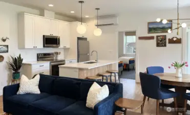 The lower level can live as it's own separate living space. You can glimpse one of the two bedrooms on this level. Your back is to the laundry room. LVP flooring and quartz countertops here and a second dishwasher.