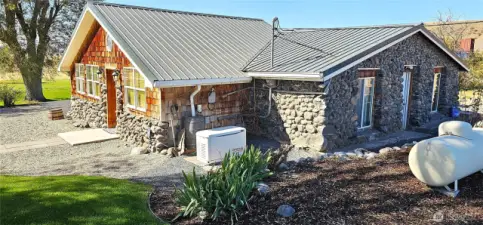 Rocks and freshly sealed cedar siding combined with metal roof = maintenance free.