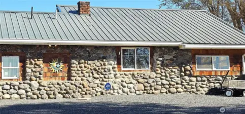 West side of the house showing off more rock and the metal roof.