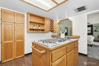 Gas cooktop built into storage island.