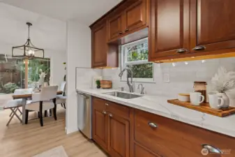 The sleek galley-style kitchen has been stylishly updated with new subway tile backsplash, a new undermount sink, a new faucet, and new quartz counters.