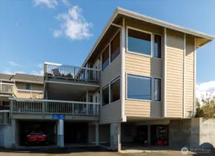 Parking is covered - second from left, with area behind it for trash & recycling bins, plus secure storage units for each unit.