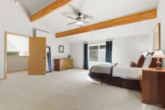 The primary bedroom retreat tucked beneath dramatic vaulted ceilings, where angled rooflines and warm wood accents create an intimate, storybook setting.