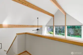 The upper-level landing overlooks the great room below, creating a dramatic sense of openness and connection between floors.