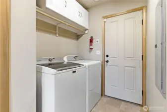 Laundry area is tucked away by the side door of the home.