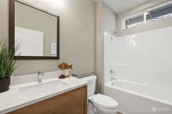 Guest bath, features quartz counter, Kohler comfort-height toilet and opening window