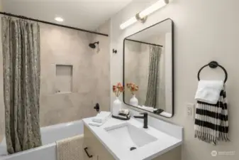 This gorgeous guest bath features custom tilework, full bathtub and vanity with under-sink storage!