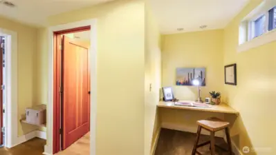 Landing at the bottom of the basement stairs with built in nook & 3/4 bath
