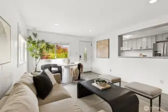 Sun-filled living area at 4612 N 21st St, Tacoma, WA — featuring wide-plank flooring, modern neutral design, open sightlines to the updated kitchen, large picture window with colorful seasonal views, and a cozy dining nook. This North Tacoma home offers a bright, welcoming layout perfect for everyday living and entertaining in a highly desirable neighborhood.