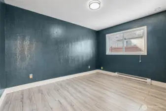Freshly updated bedroom at 4612 N 21st St, Tacoma, WA — featuring wide-plank wood-look flooring, modern paint tones, crisp white trim, and ample natural light from the adjacent hallway. This versatile North Tacoma room is perfect for use as a bedroom, home office, nursery, or creative space.