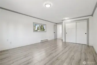 Spacious primary bedroom at 4612 N 21st St, Tacoma, WA — virtually staged to showcase its generous layout, wide-plank flooring, large windows with natural light, and flexible space for a sitting area or home office. This North Tacoma retreat offers comfort, privacy, and room to personalize with modern finishes throughout.