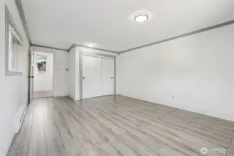 Spacious primary bedroom at 4612 N 21st St, Tacoma, WA — virtually staged to showcase its generous layout, wide-plank flooring, large windows with natural light, and flexible space for a sitting area or home office. This North Tacoma retreat offers comfort, privacy, and room to personalize with modern finishes throughout.