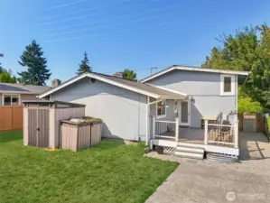 Private backyard at 4612 N 21st St, Tacoma, WA — featuring a spacious lawn, two outdoor storage sheds, a raised deck with seating area, and gated side access. This North Tacoma outdoor space is perfect for gardening, entertaining, pets, or play, with plenty of room to enjoy year-round. No HOA!