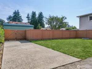 Fully fenced backyard at 4612 N 21st St, Tacoma, WA — featuring a large grassy lawn, double gate access for parking or recreational vehicles, and a private, secure space ideal for pets, play, gardening, or outdoor projects. This North Tacoma yard offers flexibility, privacy, and room to customize. NO HOA!