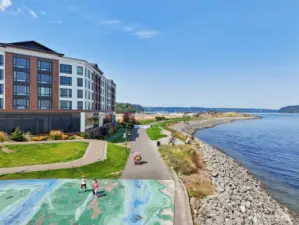 Aerial view of Point Ruston—Tacoma’s vibrant waterfront destination—featuring miles of scenic shoreline trails, dining, shopping, entertainment, and family-friendly recreation. Just a short drive from the home, offering easy access to some of the area’s most desirable amenities and Puget Sound views.