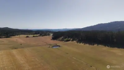 Looking South, Southwest across East Crow Valley. The property is tucked into the tree line just south of the pond.