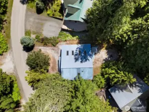 Aerial view of the cabin and roofline nestled among evergreens.