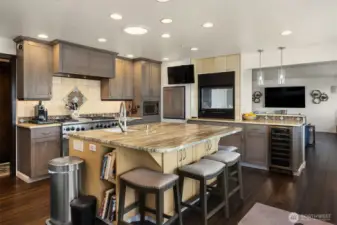 A beautiful and functional gourmet kitchen boasts of built-in fireplace, beverage cooler, and handy dumb waiter to help with unloading household items.