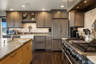 Sleek two-toned cabinetry is complemented by gorgeous solid surface countertops and custom tiled backsplash.