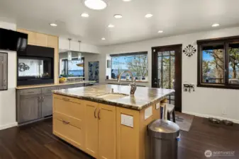 Large center island has generous room for chopping produce with built-in prep sink thoughtfully integrated into the countertop.