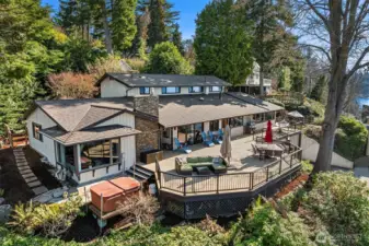 The back of the home opens to a massive entertaining deck overlooking the breathtaking waters of the Puget Sound, surrounded by lush, landscaped grounds for a true private retreat.