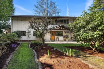 Level back yard has beautiful landscape that is well manicured with colorful native plantings.