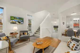 An open, spacious main room with 9' ceilings brings together living, dining, and cooking spaces, complemented by a built-in study and adjacent powder room.