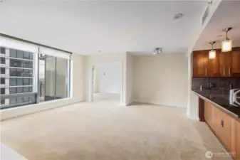 Living room with dining or study nook, and double door to primary suite.