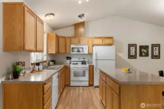 Beautiful kitchen with center island, eating bar, and ALL appliances remain!