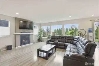 Large living room with natural gas fireplace, Luxury Vinyl plank flooring.