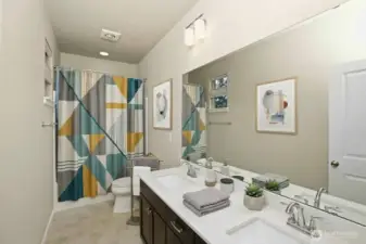 Full bath on second level features dual sinks. (some items digitally staged)