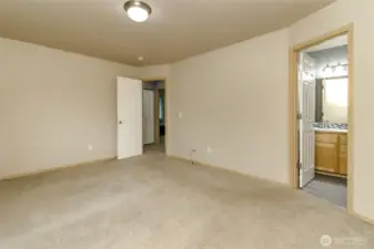 Primary bedroom with walk-in closet and 5-piece bathroom with large garden tub.
