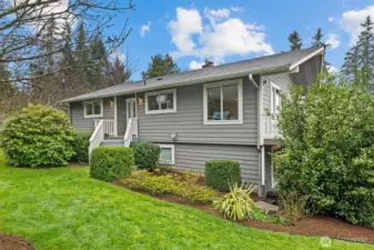 Beautifully updated home in Kenmore, showcasing mature landscaping, fresh exterior appeal, and a quiet residential setting.
