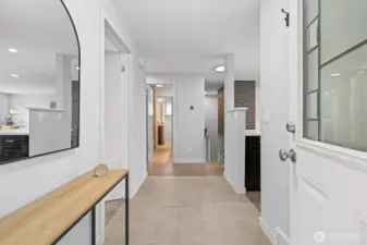 Bright interior entry foyer with tile flooring, clean modern finishes, and an open flow into the main living spaces.