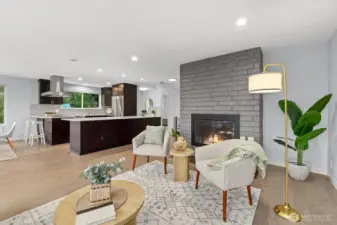 Open-concept living area with fireplace, spacious seating area, and seamless connection to the kitchen and dining spaces for easy entertaining.