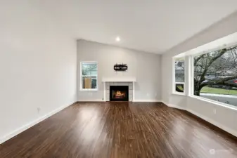 Vaulted ceiling in the front Living room. Tile wraps the gas fireplace.