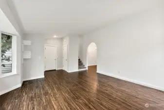 Stairs lead up to three guest bedrooms. Head through the archway to the Kitchen and Dining area.