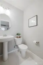 Powder room in den has builder upgraded tile flooring